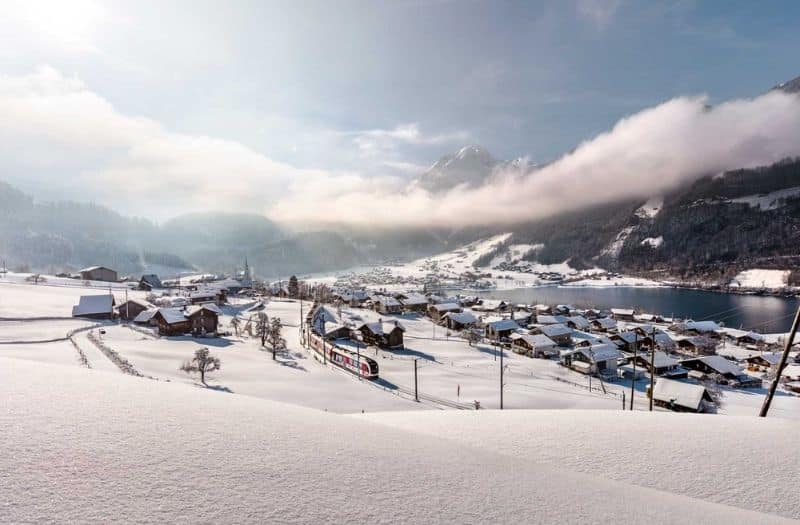 Luzern Interlaken Express travelling beside Lake Lungern in winter