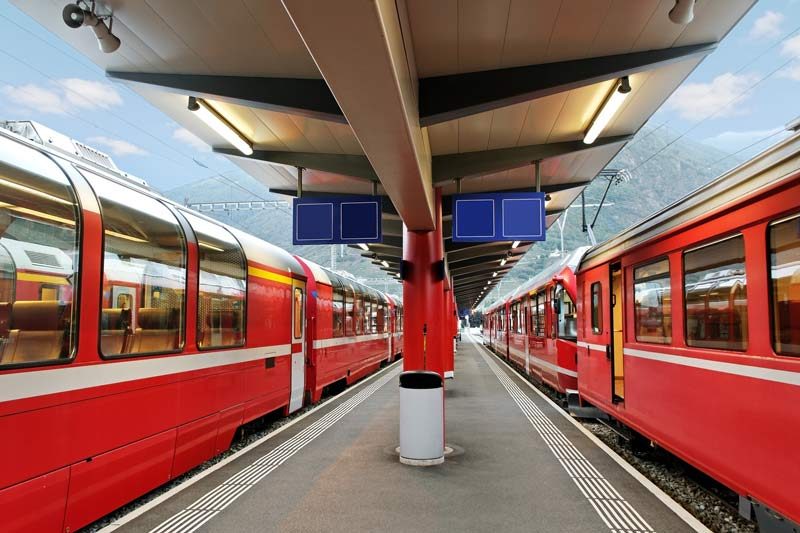 Two trains wait at a station in Switzerland